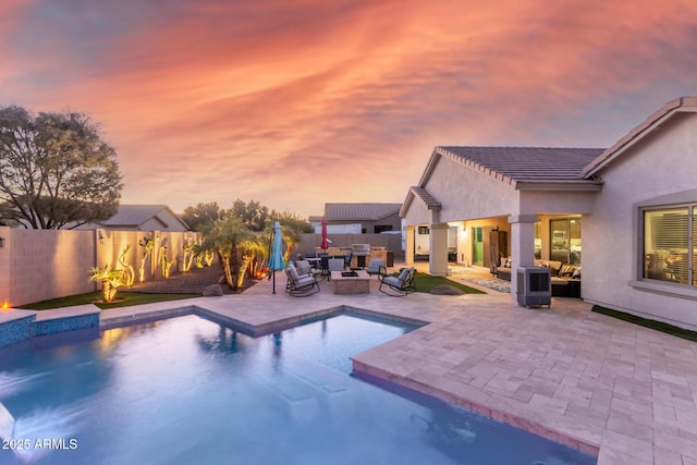 pool at dusk featuring an outdoor living space and a patio area