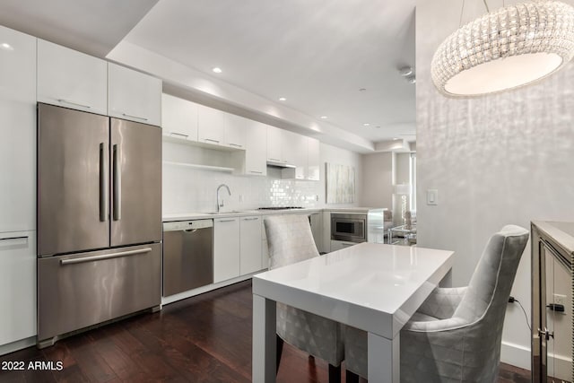 kitchen with white cabinets, pendant lighting, and appliances with stainless steel finishes