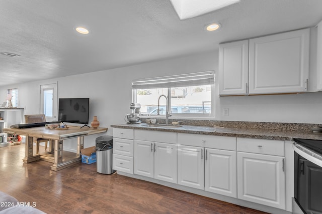 kitchen featuring dark wood-type flooring, a textured ceiling, sink, and white cabinets