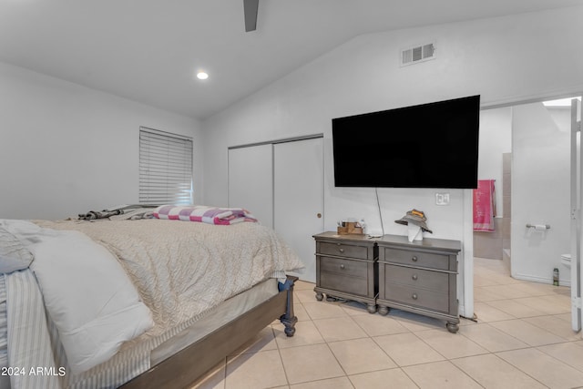 bedroom with lofted ceiling, light tile patterned floors, ceiling fan, and a closet