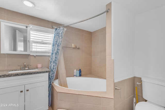 full bathroom with vanity, toilet, shower / tub combo, and tile walls