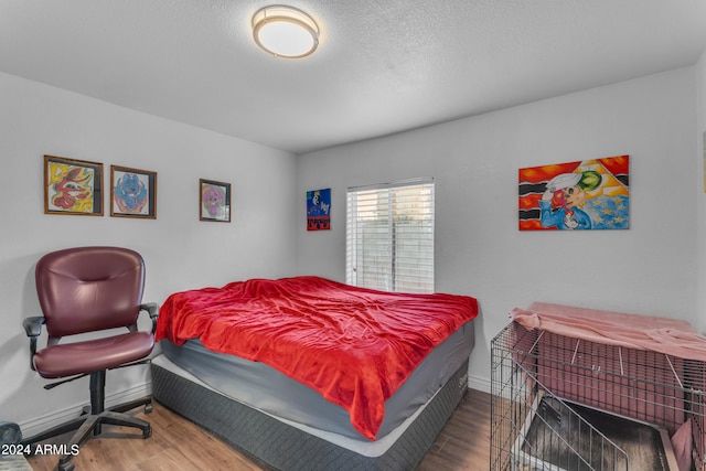 bedroom with wood-type flooring and a textured ceiling