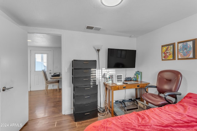 bedroom with a textured ceiling and wood-type flooring