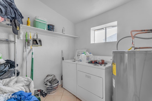 laundry area featuring light tile patterned floors, water heater, and washing machine and clothes dryer