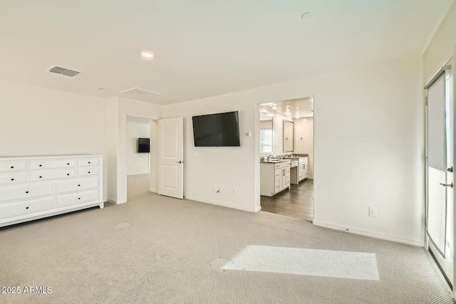 unfurnished bedroom featuring light colored carpet, connected bathroom, and sink