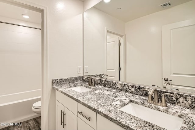 full bathroom featuring toilet, tub / shower combination, wood-type flooring, and vanity