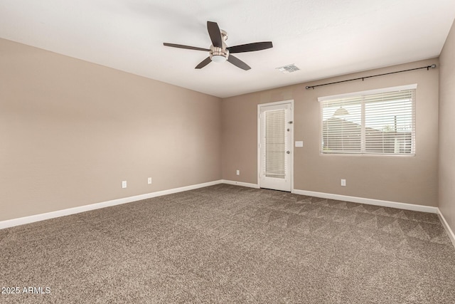 empty room with visible vents, baseboards, a ceiling fan, and dark carpet