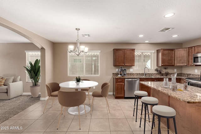 kitchen featuring a sink, stainless steel appliances, visible vents, and light tile patterned floors