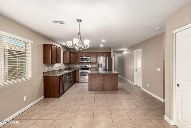 kitchen featuring visible vents, stone counters, a notable chandelier, stainless steel appliances, and a sink