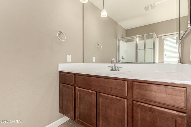 bathroom featuring tile patterned flooring, a shower stall, vanity, and baseboards