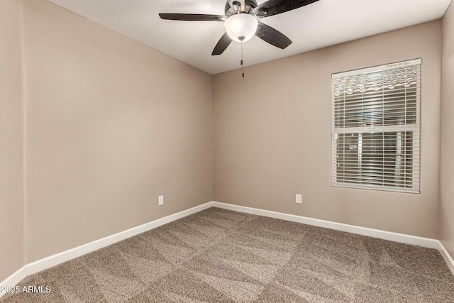 carpeted spare room with a ceiling fan and baseboards