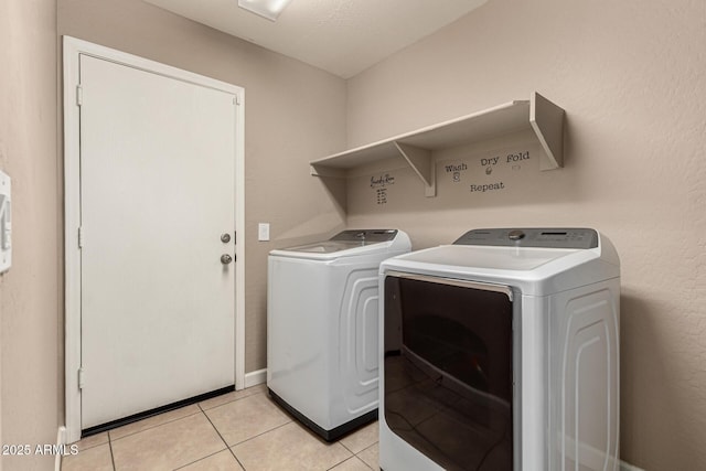 washroom with light tile patterned floors, independent washer and dryer, and laundry area