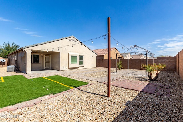 rear view of property with stucco siding, a fenced backyard, cooling unit, a patio area, and a tiled roof