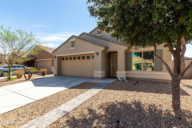 view of front facade with stucco siding, a garage, concrete driveway, and a tiled roof