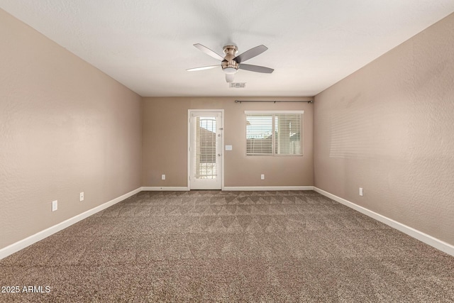 unfurnished room with visible vents, a ceiling fan, carpet flooring, baseboards, and a textured wall