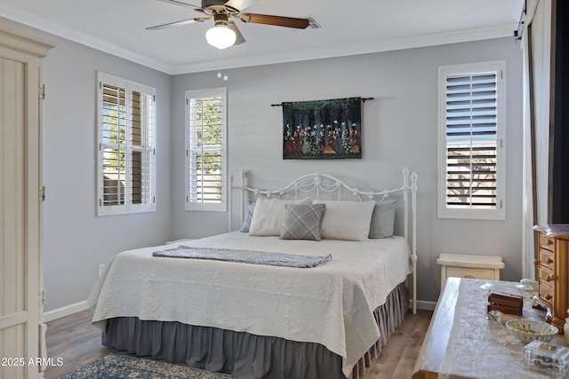 bedroom featuring crown molding, ceiling fan, hardwood / wood-style floors, and multiple windows