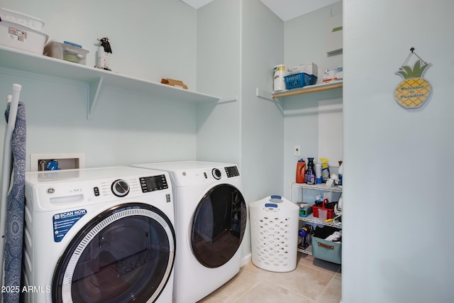 clothes washing area featuring washer and dryer and light tile patterned flooring