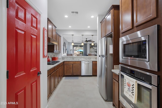 kitchen with light tile patterned floors, stainless steel appliances, sink, and ceiling fan