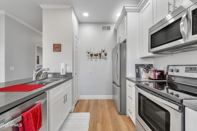 kitchen with sink, white cabinetry, crown molding, light wood-type flooring, and stainless steel appliances