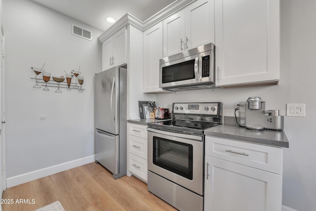 kitchen featuring stainless steel appliances, white cabinets, and light wood-type flooring