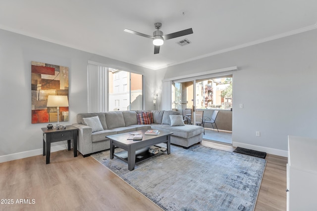 living room featuring crown molding, ceiling fan, and light wood-type flooring