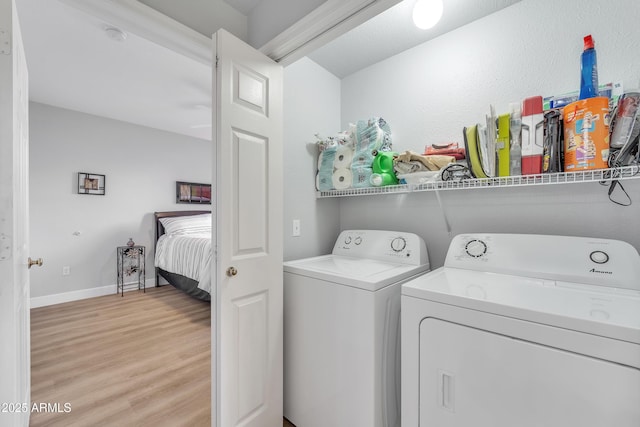 laundry room with separate washer and dryer and light hardwood / wood-style flooring