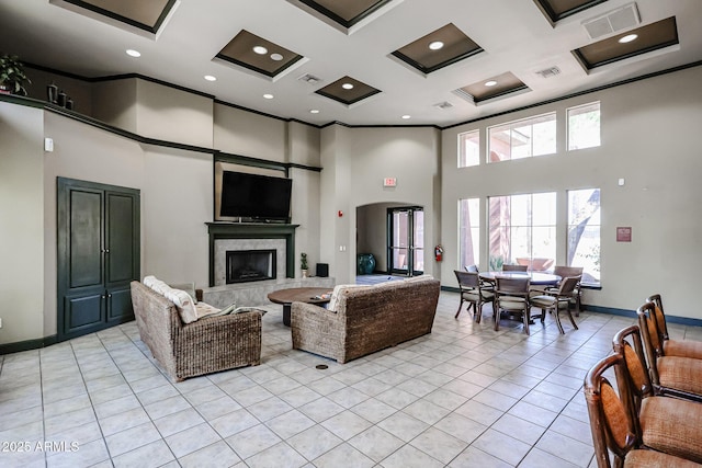 tiled living room featuring coffered ceiling, a high end fireplace, ornamental molding, and a high ceiling