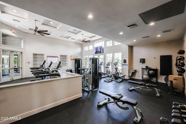 exercise room featuring a towering ceiling, a wealth of natural light, french doors, and ceiling fan