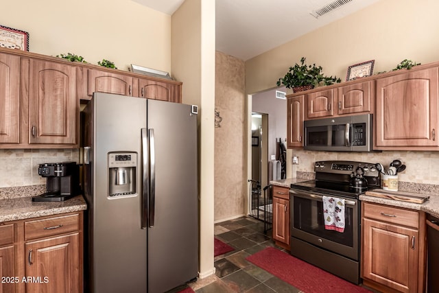 kitchen featuring visible vents, appliances with stainless steel finishes, brown cabinets, and backsplash