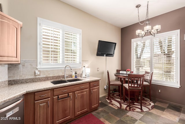 kitchen with a chandelier, dishwashing machine, tasteful backsplash, and a sink