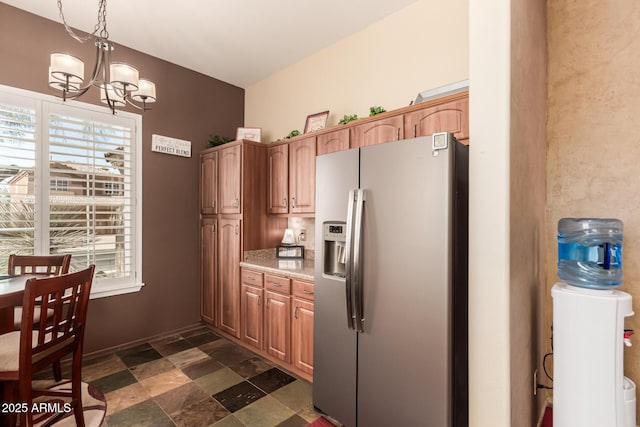 kitchen featuring a chandelier, light countertops, stainless steel fridge, and a wealth of natural light