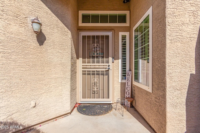 entrance to property with stucco siding