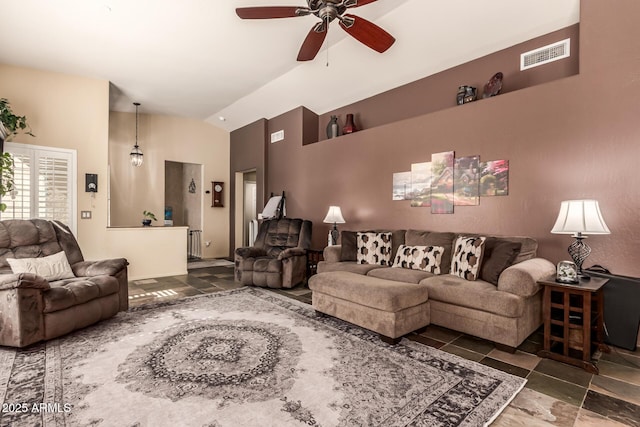 living area with visible vents, vaulted ceiling, stone tile floors, and ceiling fan