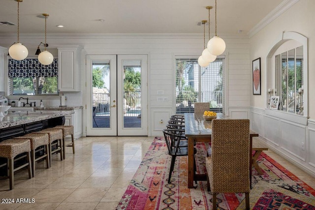 dining room with light tile patterned floors, crown molding, and french doors