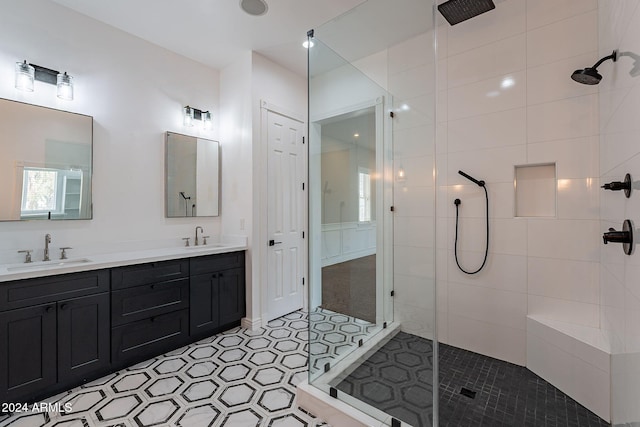 bathroom with a tile shower and vanity