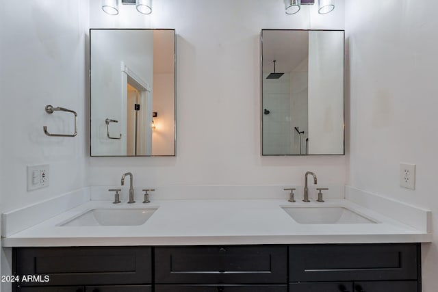 bathroom with tiled shower and vanity