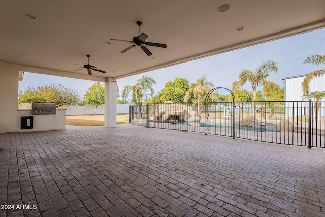 view of patio / terrace featuring ceiling fan, exterior kitchen, and a grill