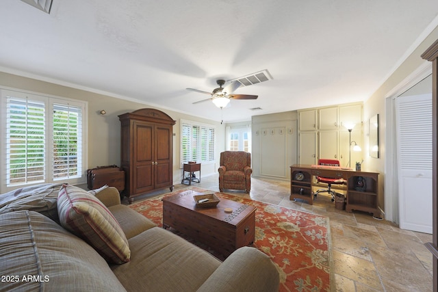 living area with stone tile floors, ceiling fan, visible vents, and a wealth of natural light