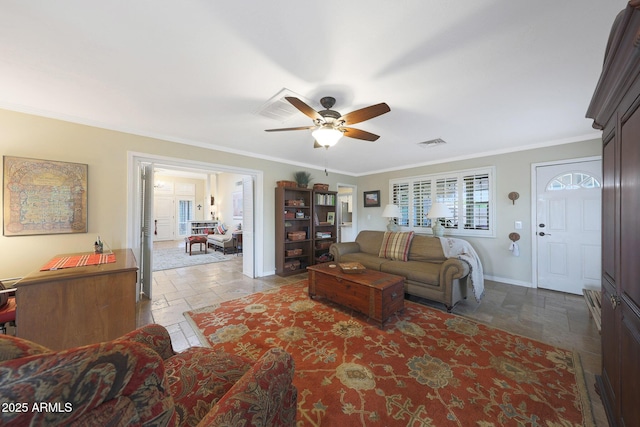 living area featuring a ceiling fan, visible vents, crown molding, baseboards, and stone tile floors