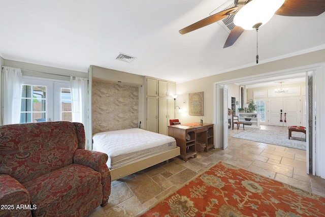 bedroom with stone tile floors, crown molding, visible vents, and ceiling fan with notable chandelier