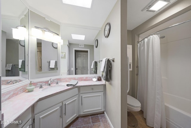 bathroom featuring vanity, stone finish flooring, toilet, and a skylight