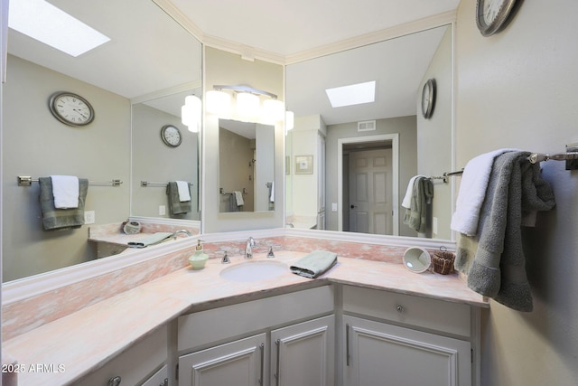 bathroom featuring a skylight, vanity, and visible vents