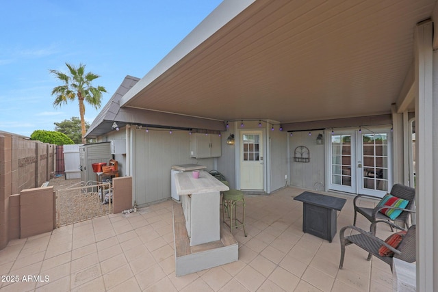 view of patio / terrace with french doors, a fenced backyard, and outdoor dry bar