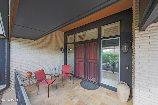 view of exterior entry featuring brick siding