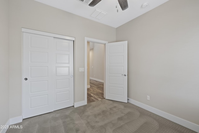 unfurnished bedroom with ceiling fan, light colored carpet, and a closet