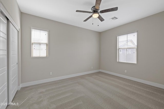 carpeted spare room featuring ceiling fan and a wealth of natural light