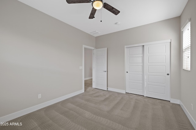 unfurnished bedroom with light carpet, a closet, and ceiling fan