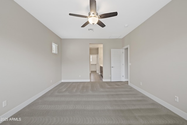 carpeted spare room featuring ceiling fan