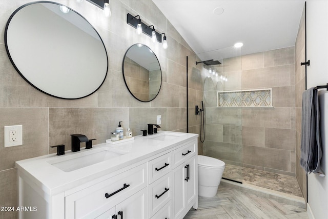 bathroom with a tile shower, tile walls, parquet floors, vanity, and toilet