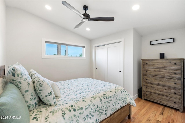 bedroom featuring vaulted ceiling, ceiling fan, light hardwood / wood-style floors, and a closet